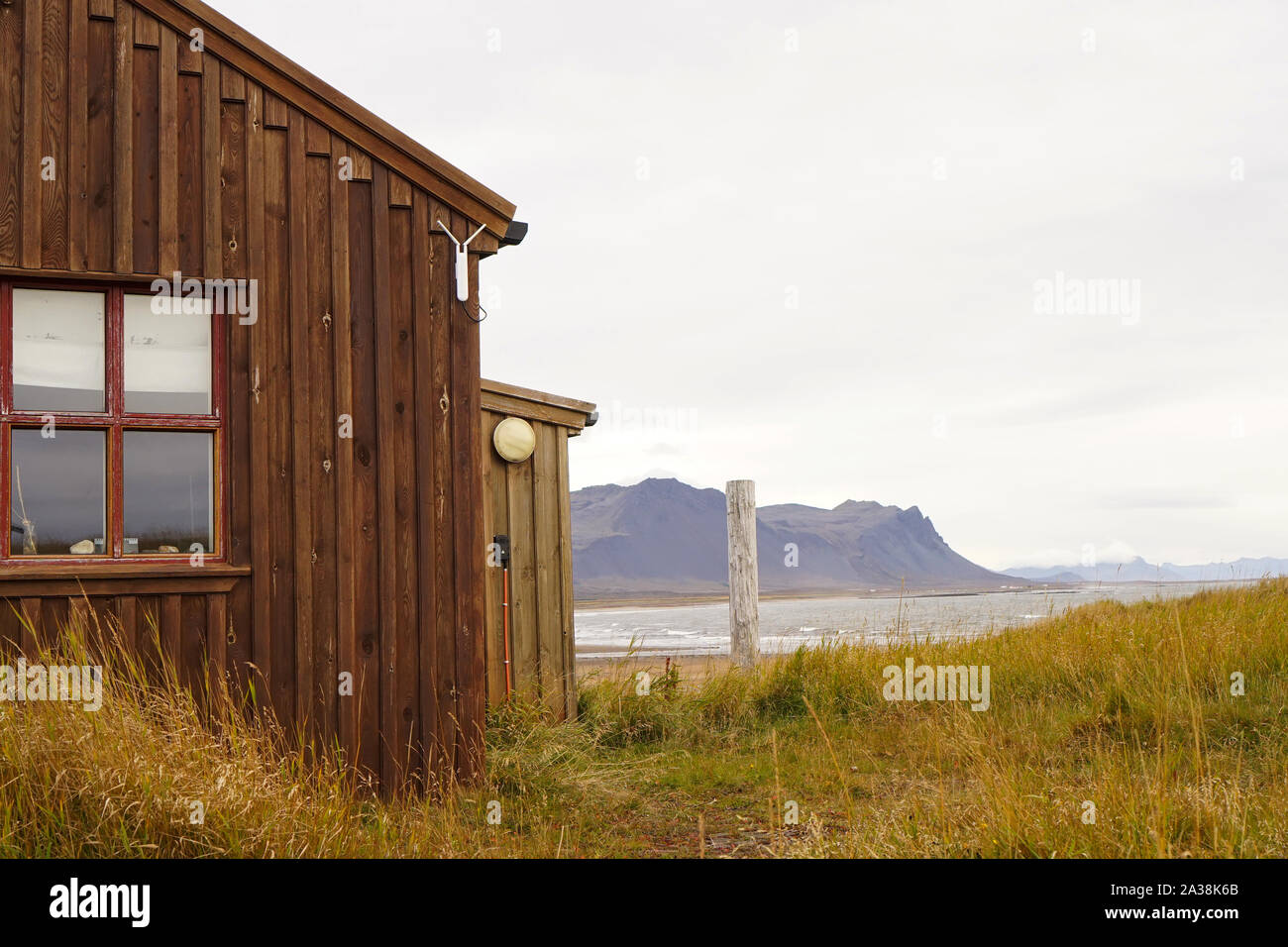 A traditional Icelandic wooden hut with mountain range in background Stock Photo