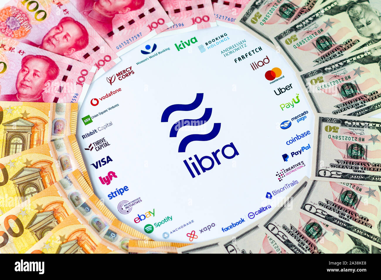 Libra Association logo on paper brochure and USD, CNY, EUR banknotes. Illustrative for Facebook plan to create global currency called Libra. Stock Photo