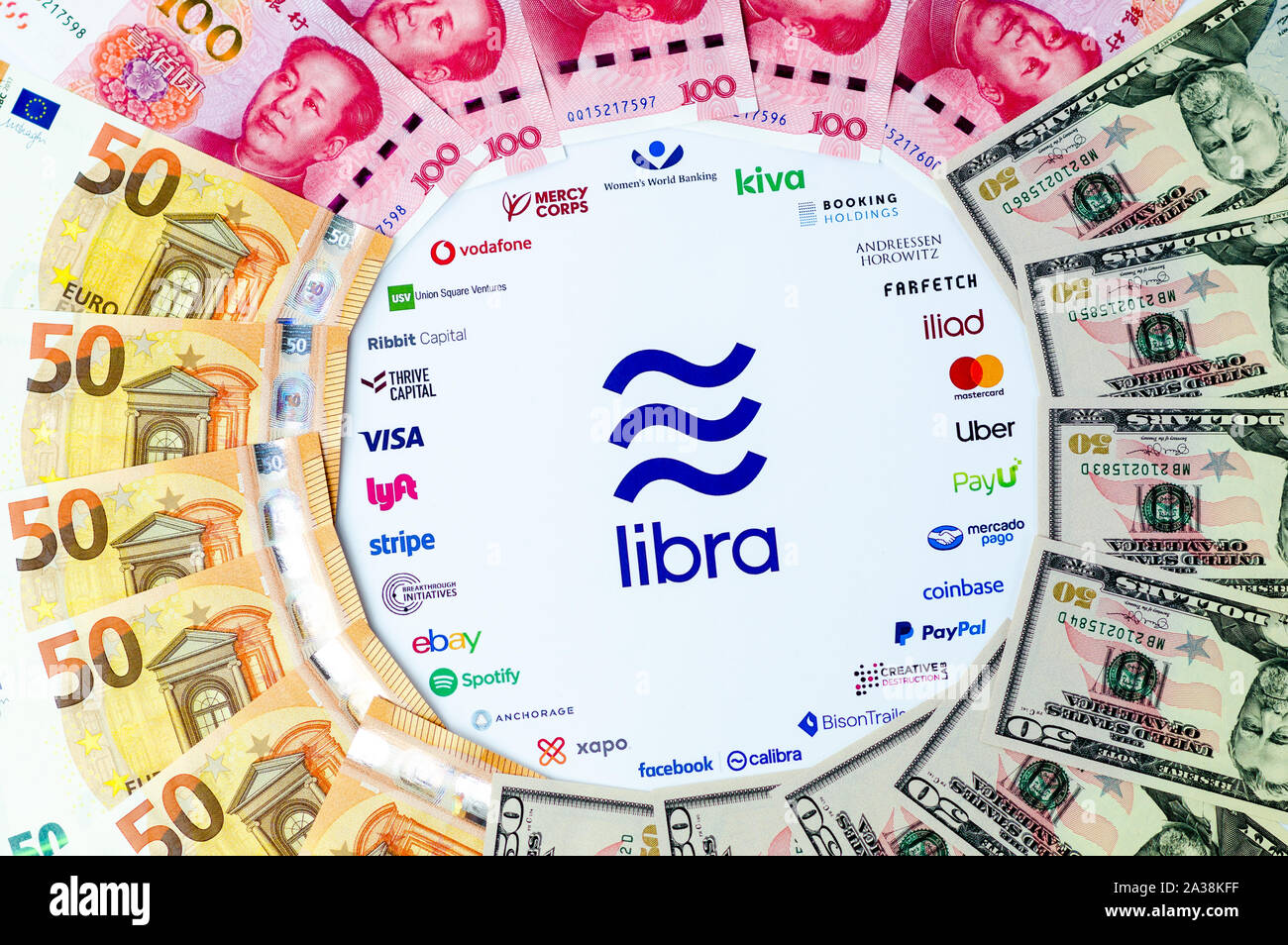 Libra Association logo on paper brochure and USD, CNY, EUR banknotes. Illustrative for Facebook plan to create global currency called Libra. Stock Photo