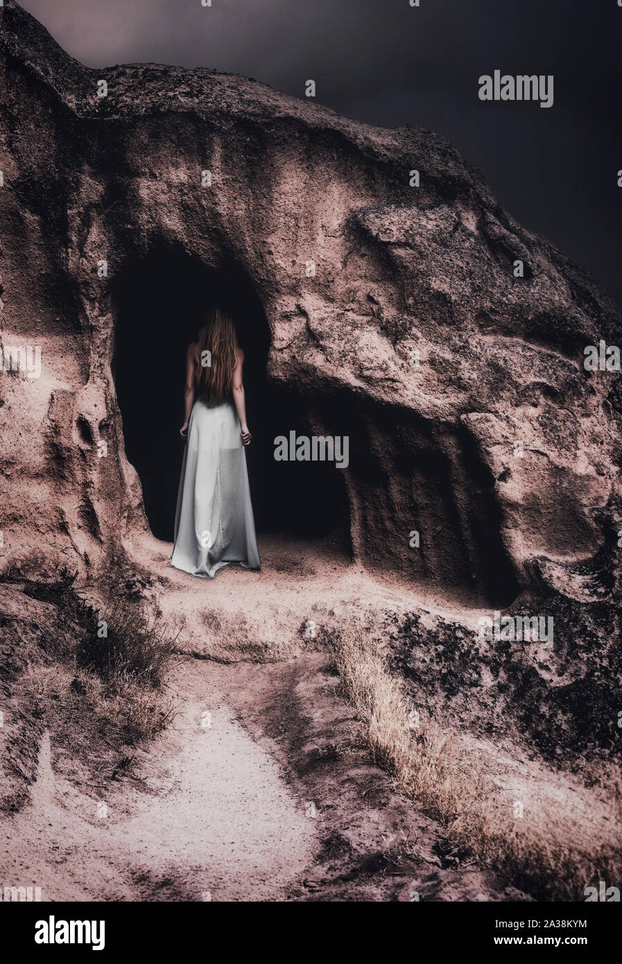 Woman In A Dress Entering A Cave Stock Photo Alamy