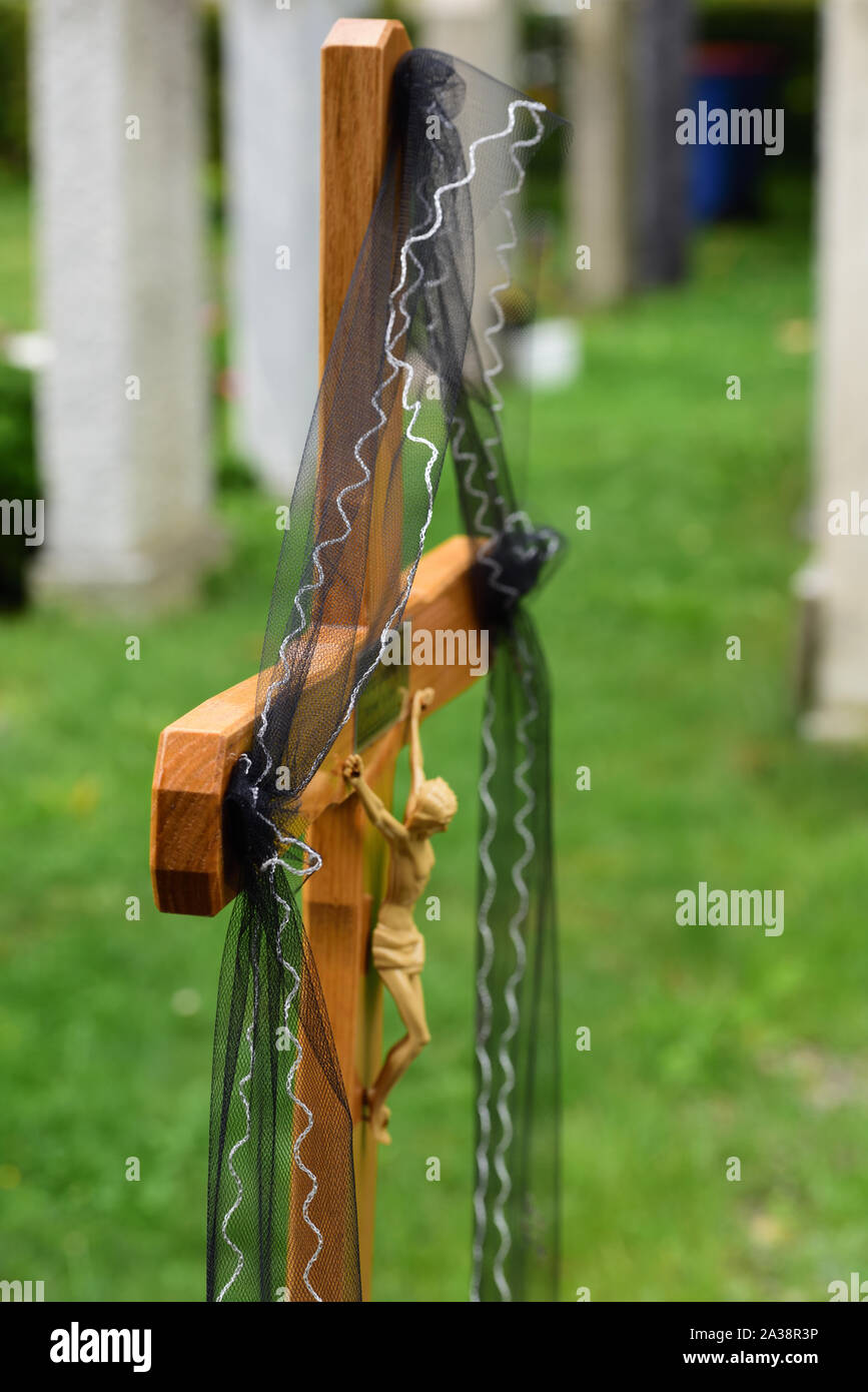 Close-up and background of a simple wooden cross in a Christian graveyard with a black ribbon Stock Photo