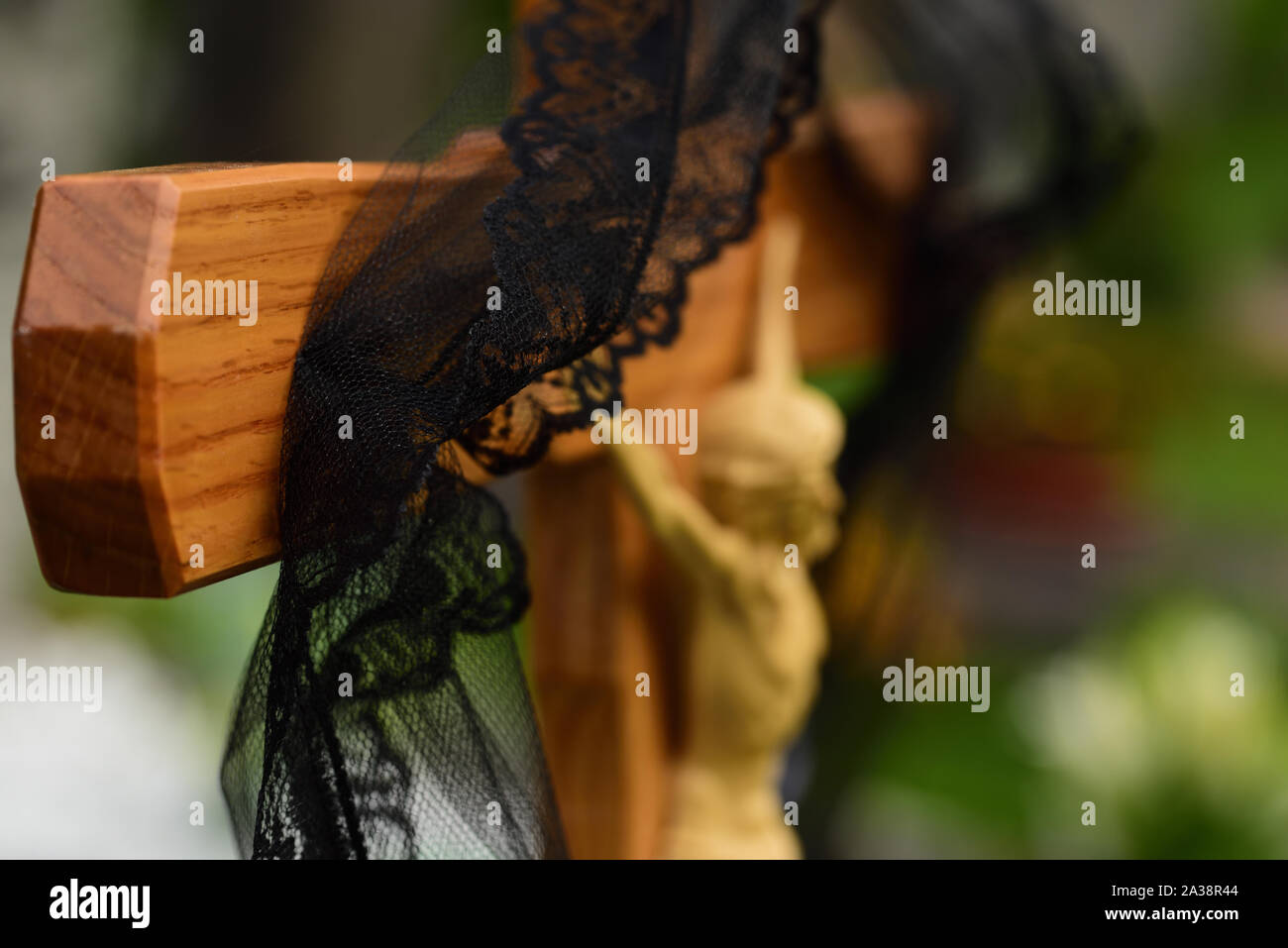 Close-up and background of a simple wooden cross in a Christian graveyard with a black ribbon Stock Photo