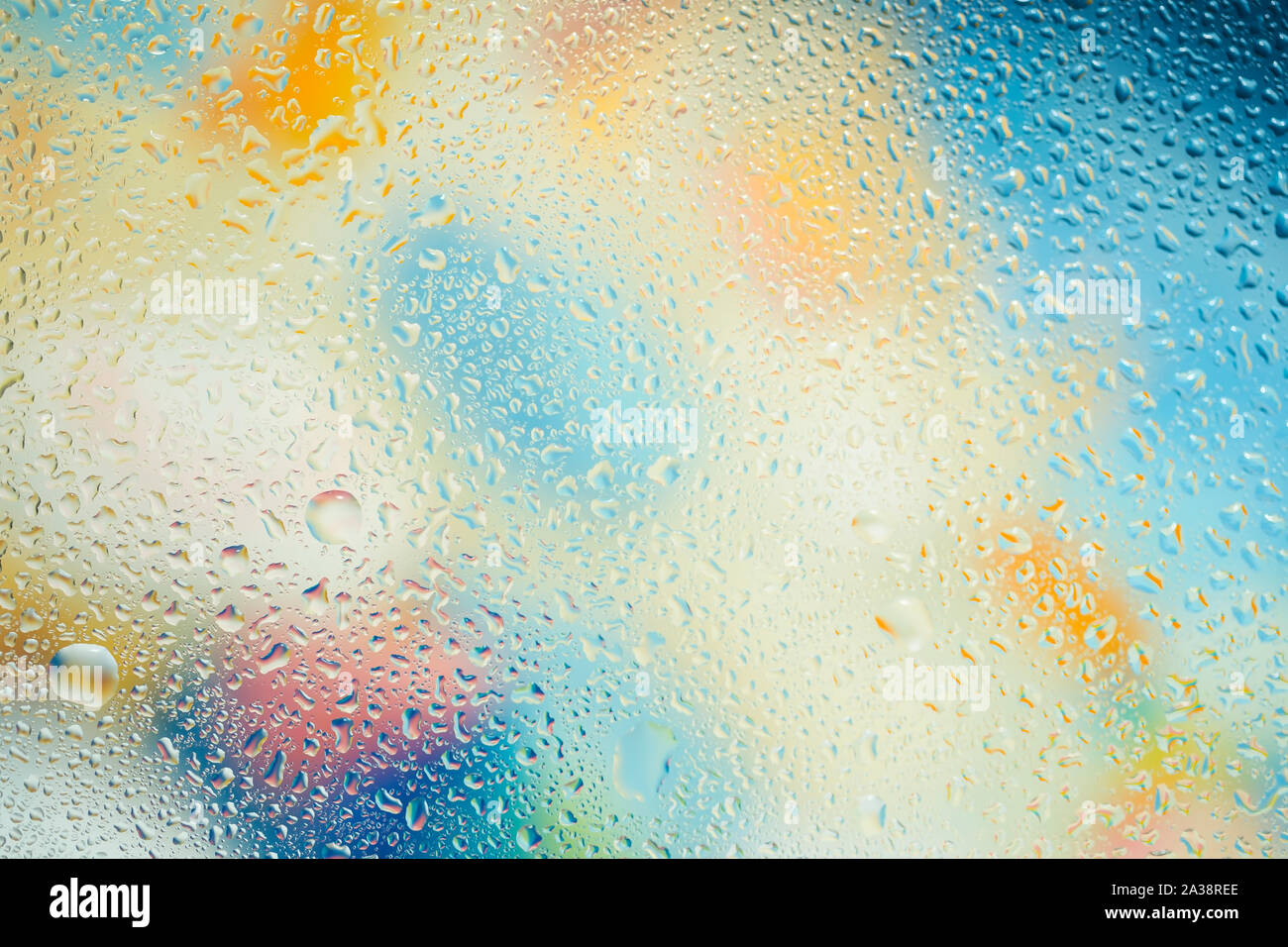 Water drops over colorful glass background Stock Photo