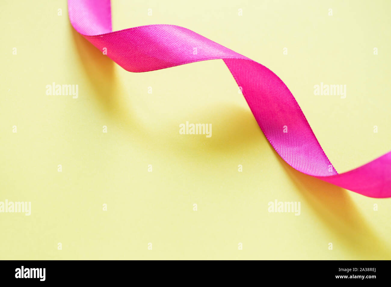 Pink ribbon on yellow background Stock Photo