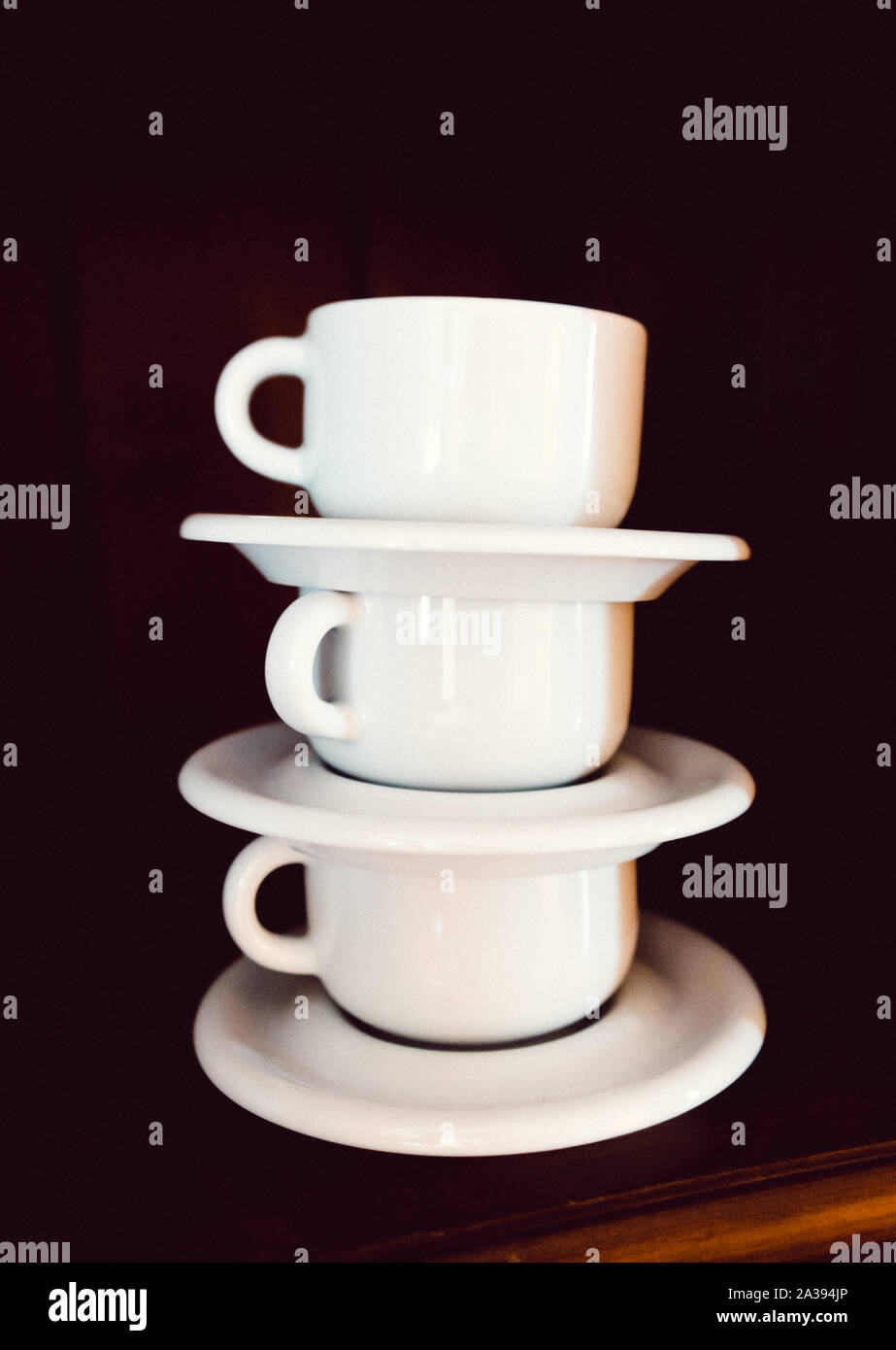 Set of white cups in a cupboard, piled Stock Photo