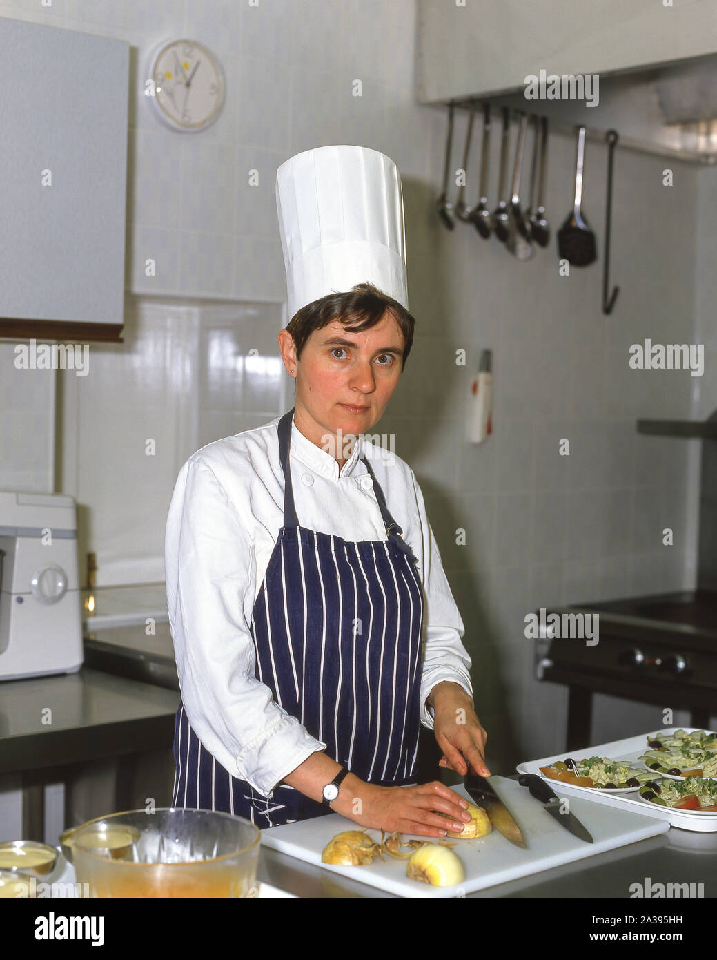 Female chef working in kitchen, Guildford, Surrey, England, United Kingdom Stock Photo