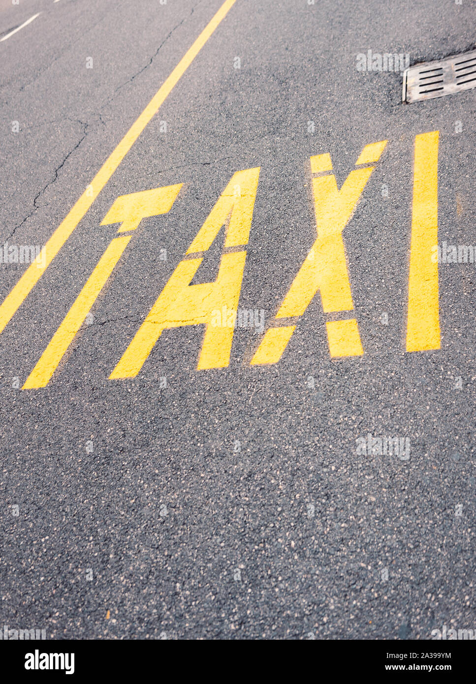 Yellow Taxi sign on blacktop in the city center Stock Photo