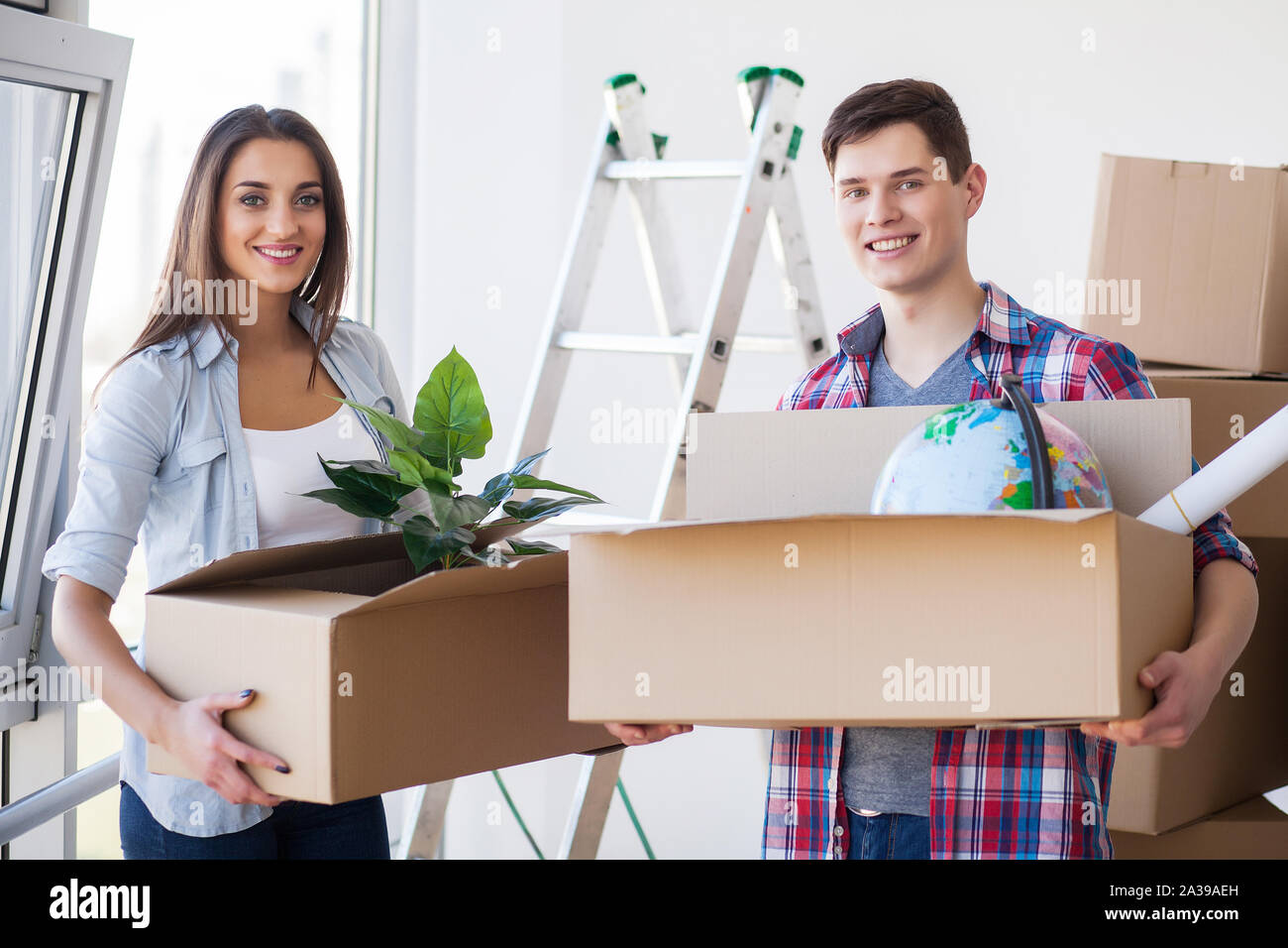 Happy young couple moving to new home Stock Photo - Alamy