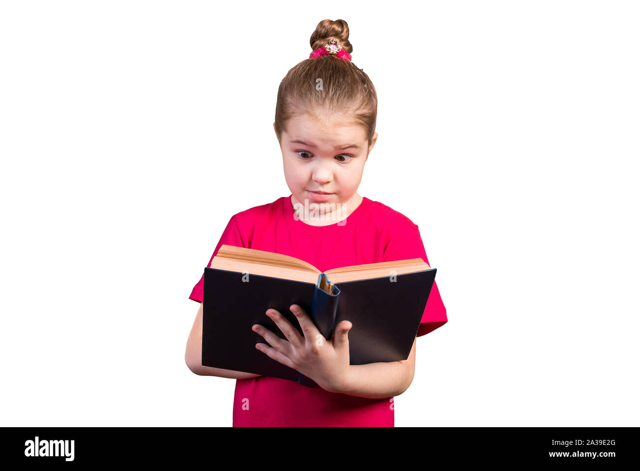 Little girl reads an old book with interest. Isolated on a white background. Stock Photo