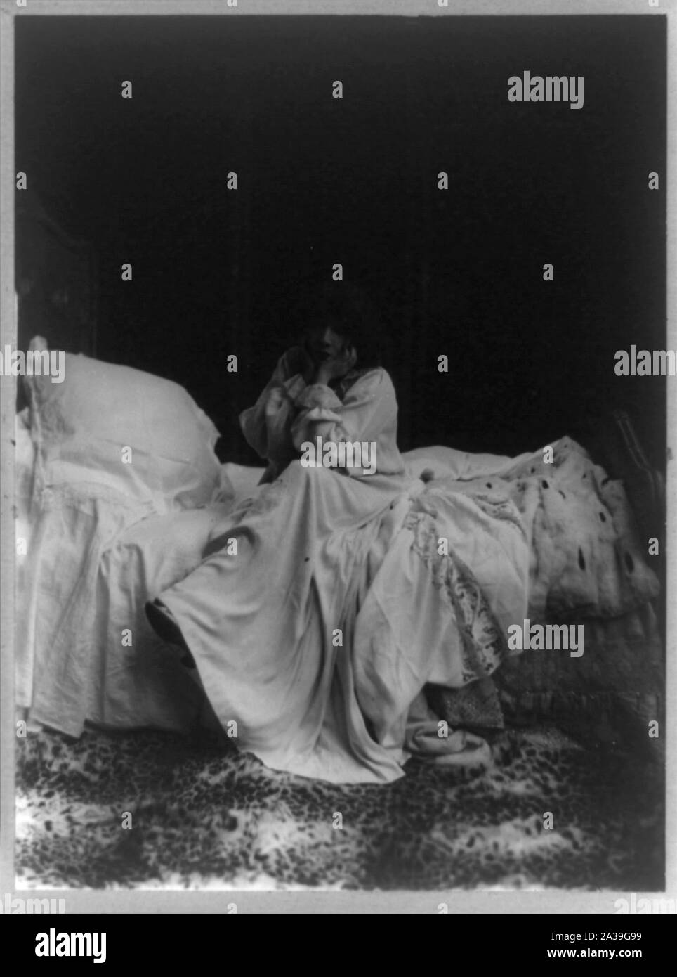 Sarah Bernhardt as Camille, full-length portrait, seated on bed, facing slightly left, head resting on hands Stock Photo