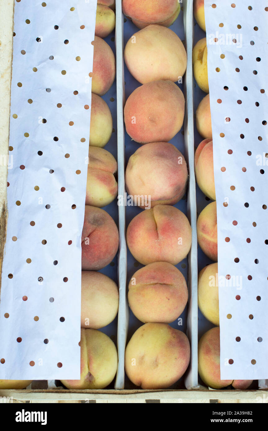 Ripe peaches prepared for sale are in boxes and packed with special paper. Russia. Stock Photo