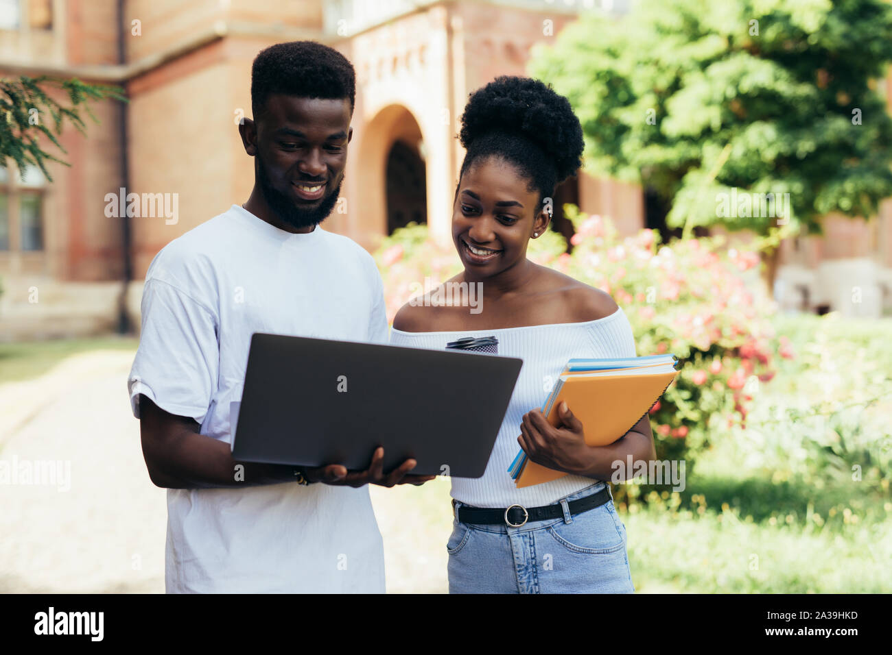 College students sitting and talking on campus lawn Stock Photo - Alamy
