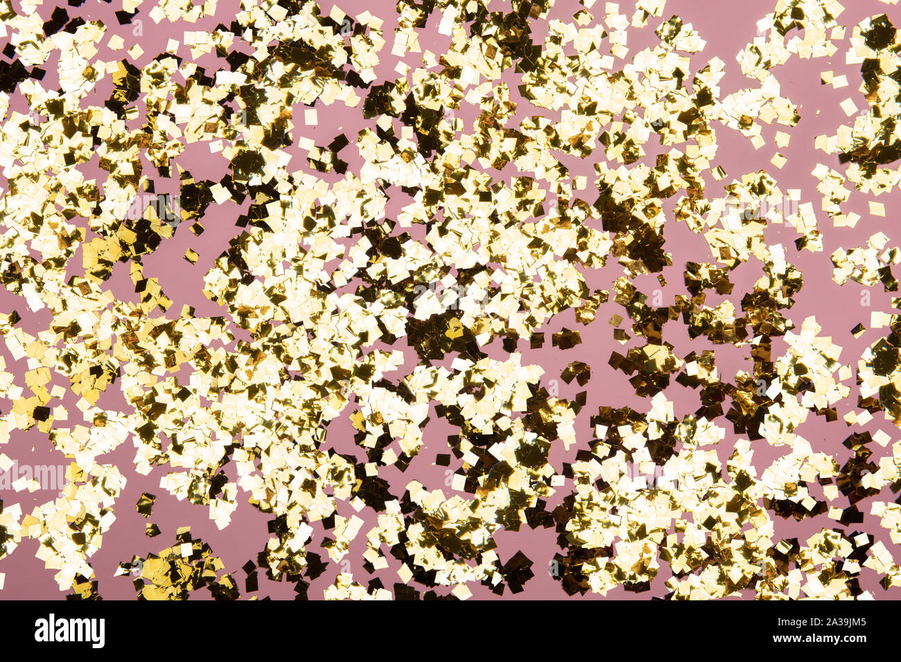 Golden confetti glitter on pink background. Festive holiday pastel ...