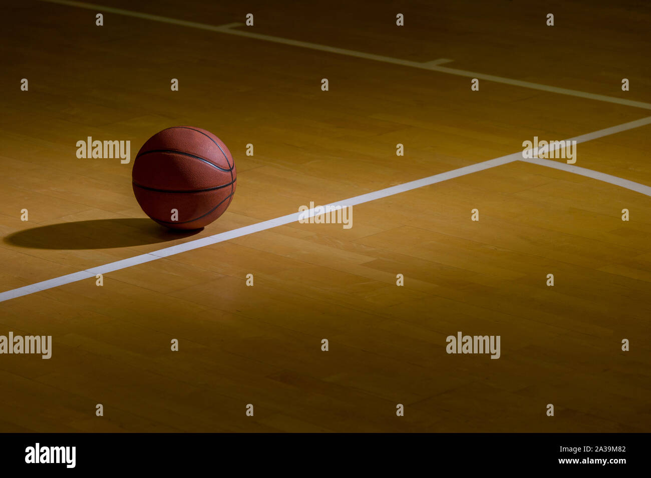 Basketball On Hardwood Court Floor With Spot Lighting Stock Photo Alamy
