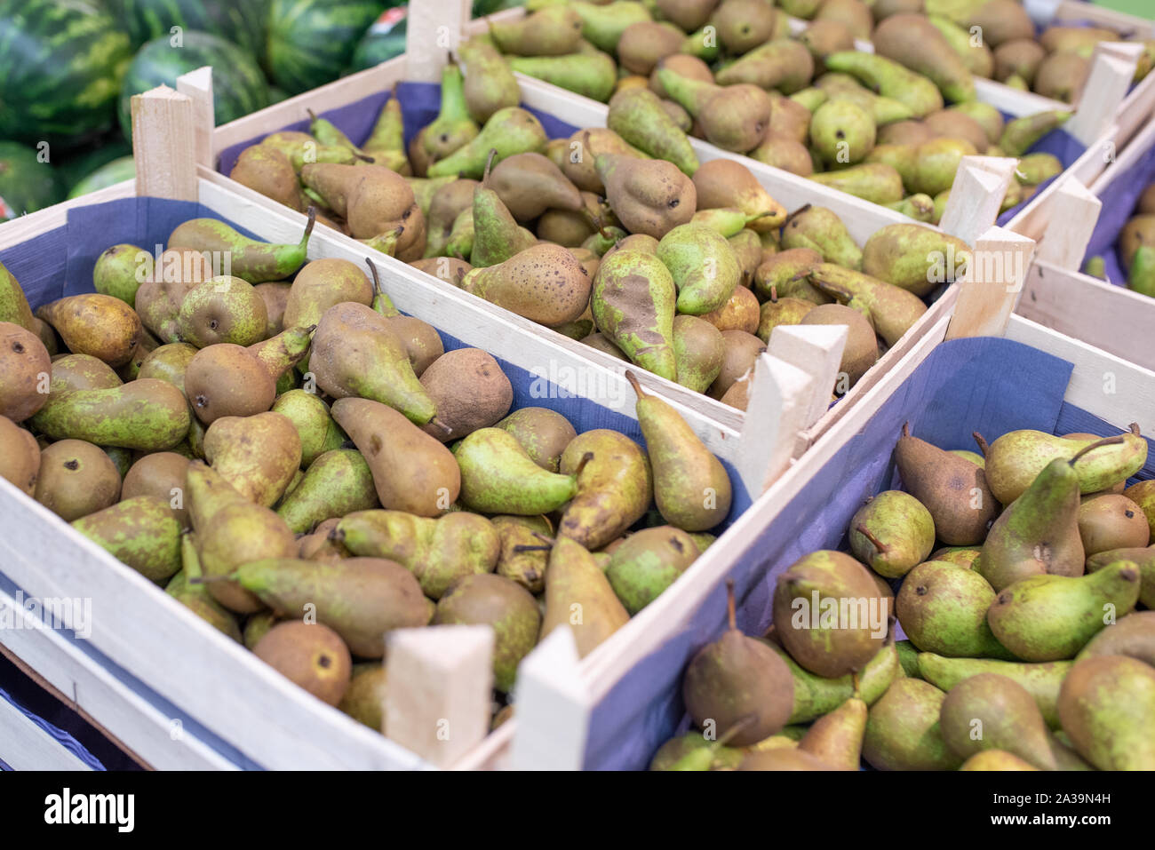 Yellow and green pears on a shelf of the refrigerator, in a supermarket