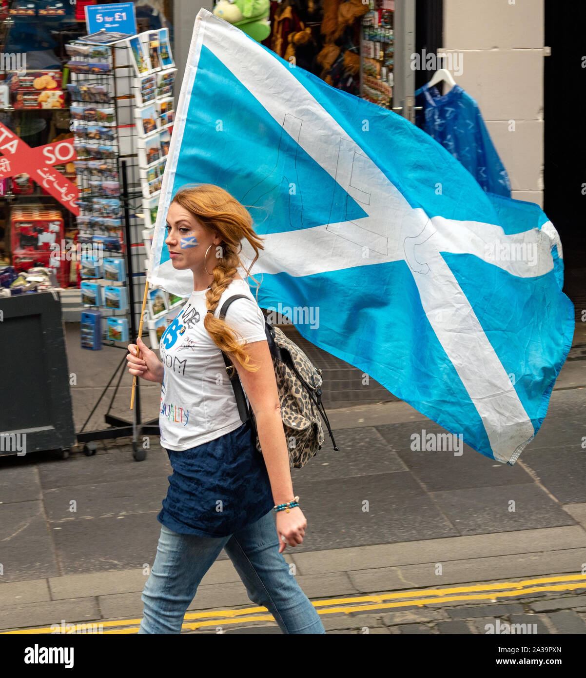Female with painted face carrying a Saltire at 'All Under One Banner - AUOB' rally - Edinburgh, Scotland, UK - 05 October 2019 Stock Photo