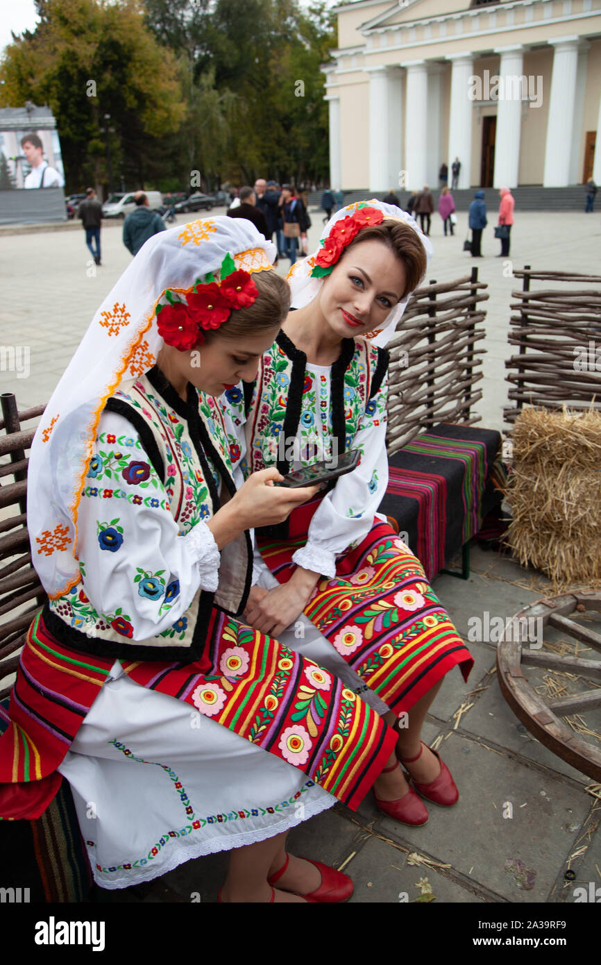 Chisinau, Moldova - October 5, 2019: Two young women in traditional Balkanic costumes at a festival in Chisinau, the capital of Moldova. Rest in the p Stock Photo