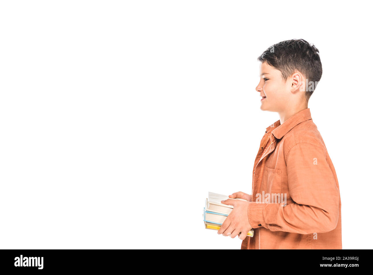 side view of smiling kid in shirt holding books isolated on white Stock Photo