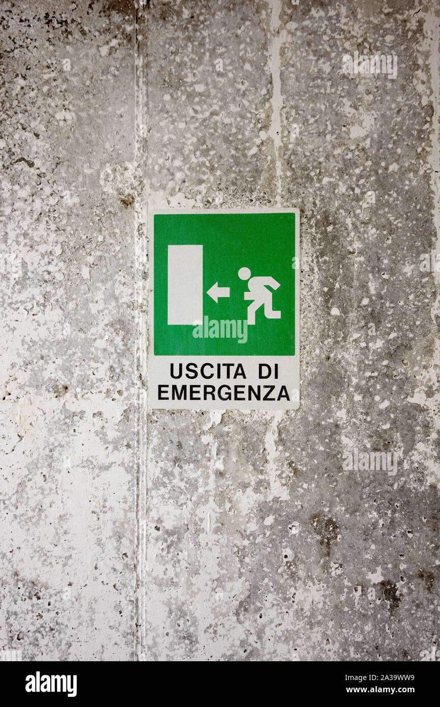 Green Emergency Exit Sign on a wall with italian words Stock Photo