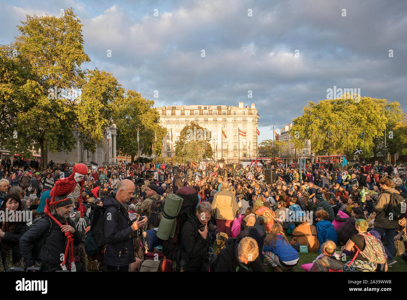 October 6th, 2019, London, UK : Thousands of Extinction Rebellion activists gather at Marble Arch for the Opening Ceremony, calling for ' a moment to pause, to draw breath, to take a look inside ourselves and step into this evolutionary moment together'. Several activists lit 'beacons of truth' which will be taken to the various actions in London.  '‘We understand life to be precious. We are hearing the need for a pause so that we can listen for what questions humanity must ask itself before it finds answers that are in full service to all life.  We are asking humanity to listen carefully to i Stock Photo