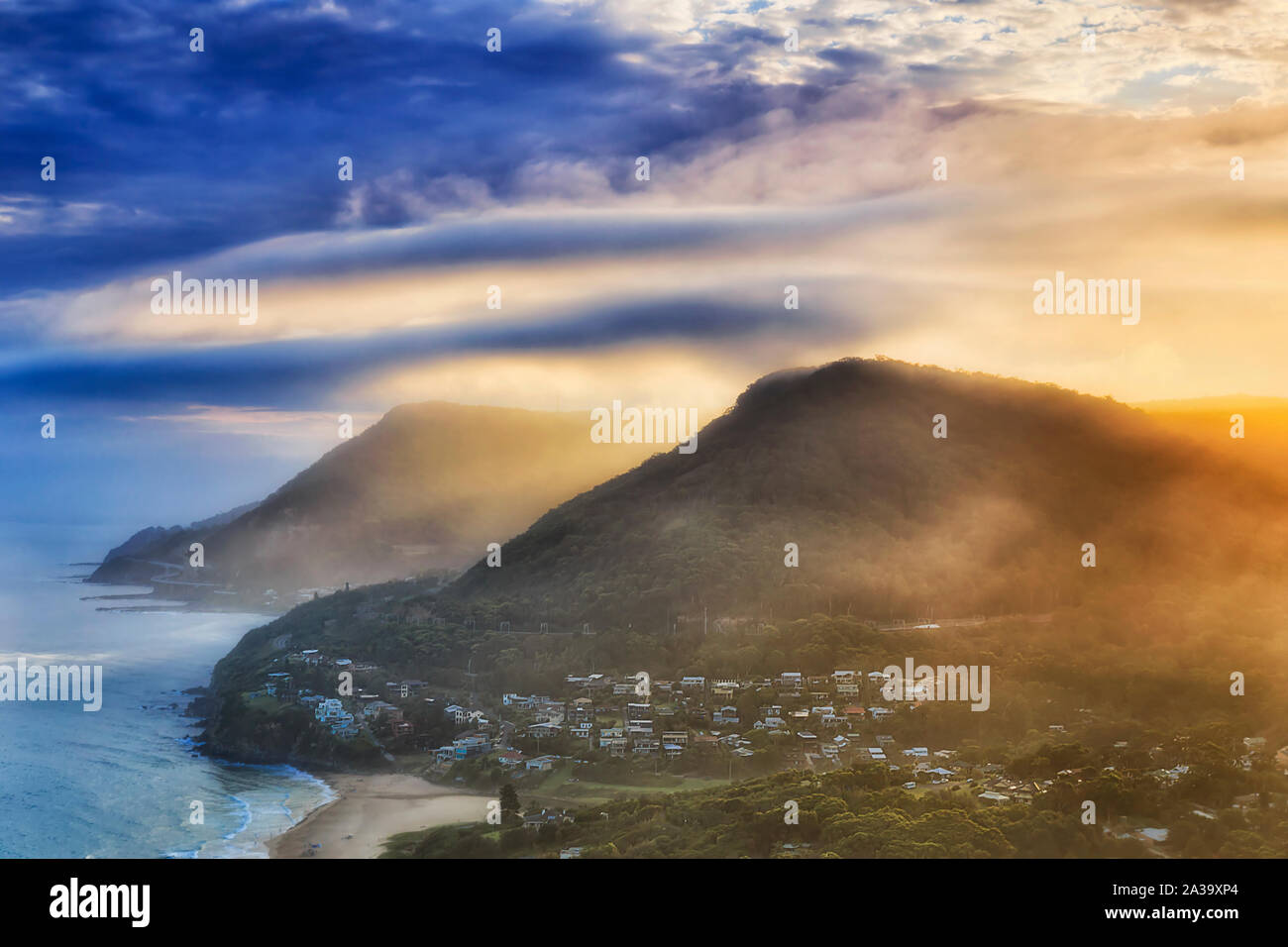 Range of gum-tree covered hills on South Coast off Sydney part of Grand Pacific Driver scenic route with famous Sea Cliff Bridge at sunset from elevat Stock Photo