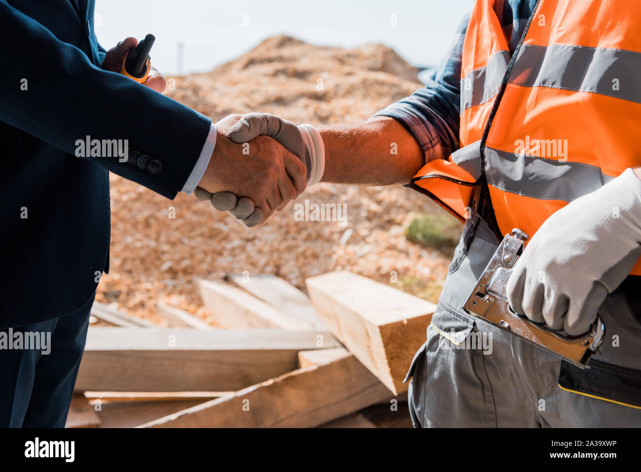 cropped view of constructor and businessman shaking hands Stock Photo