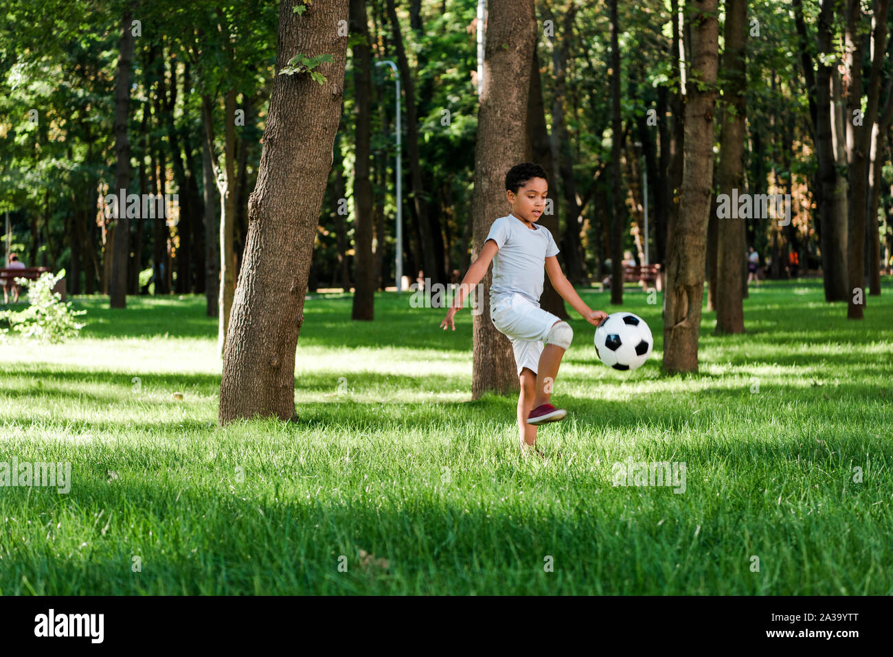 cute african american child playing football on grass Stock Photo - Alamy