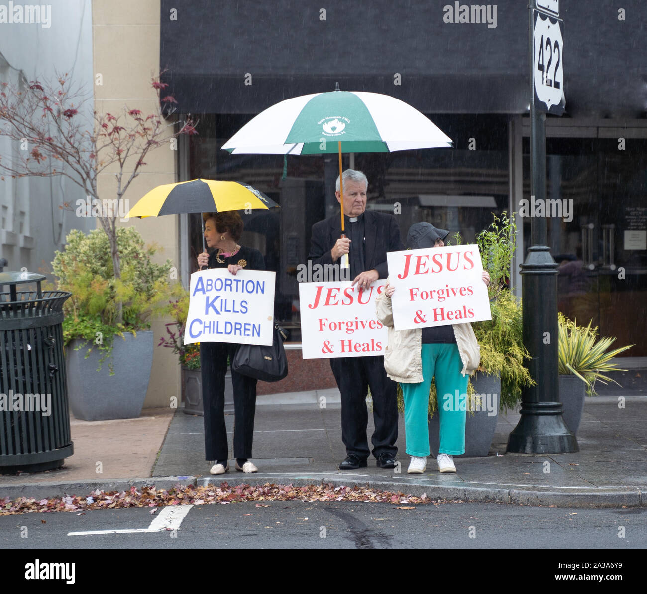 West Reading, Pennsylvania/USA – October 6, 2019: Life Chain Event: Heavy rain does not deter two senior women  and one man from participating in righ Stock Photo