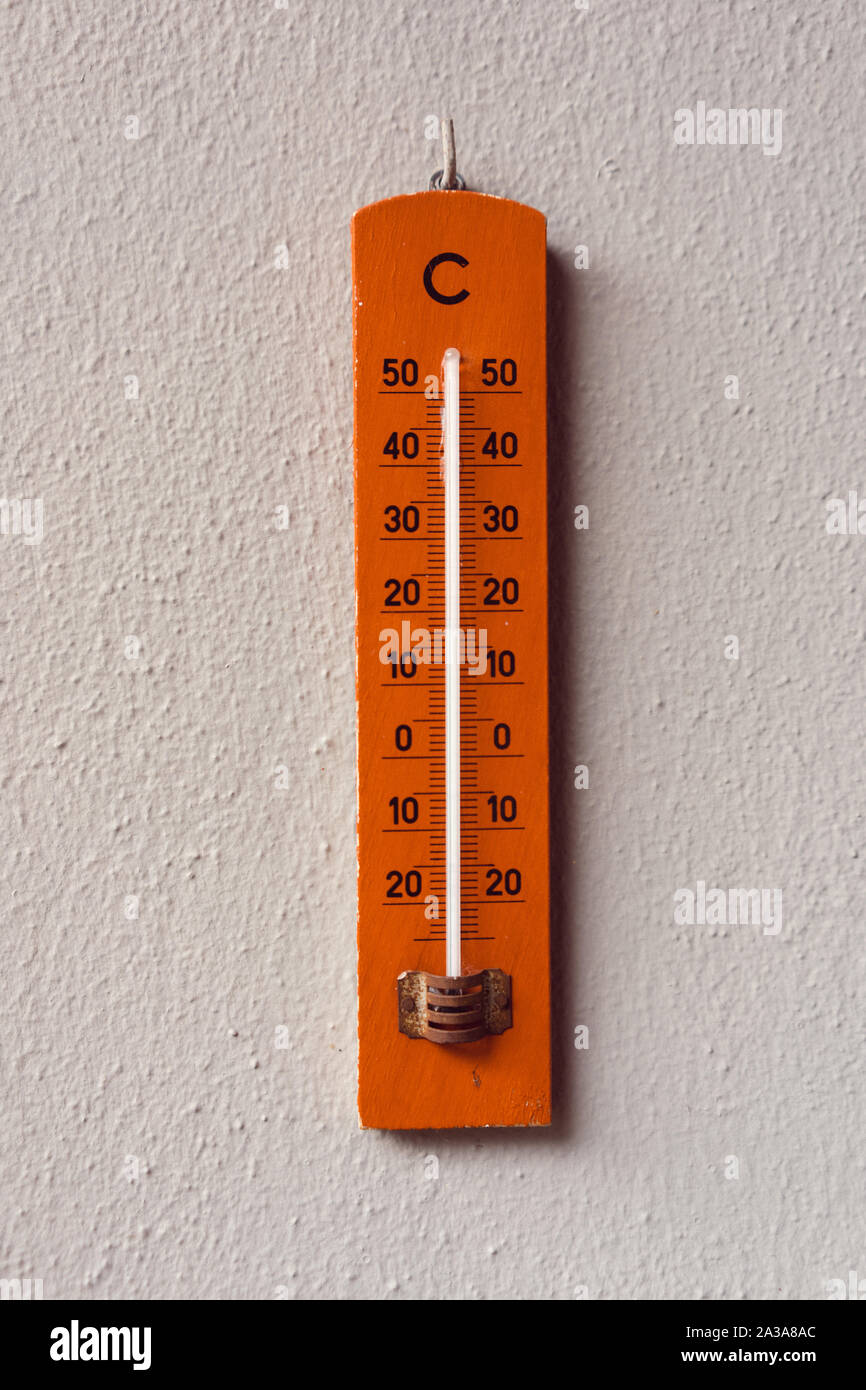 Red Termometer hangin on a wall Stock Photo
