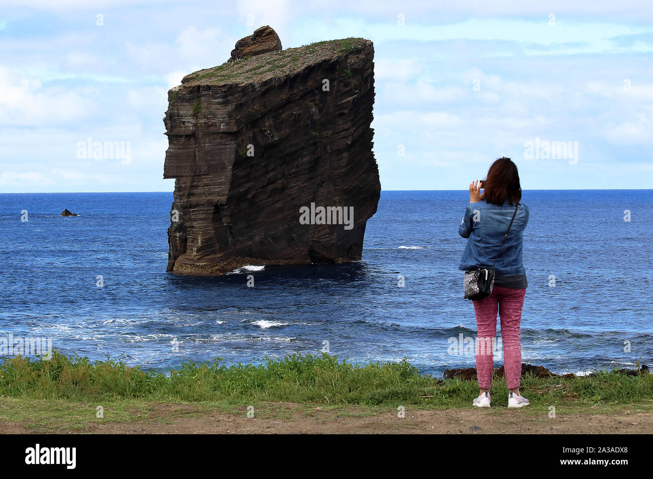 A tourist taking picture of the iconic wild rock formations next to Mosteiros in São Miguel island, Azores, Portugal Stock Photo