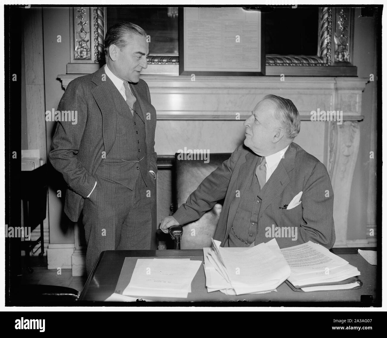 Senate Naval Affairs Committee hears Chief of Naval Aeronautics in secret session. Washington, D.C., April 7. Rear Admiral Arthur D. Cook, Chief Naval Aeronautics, pictured with Senator David I. Walsh, (left) Chairman of the Senate Naval Affairs Committee, before whom A.D. Cook appeared today in secret session. When questioned on the Naval Expansion Bill, Admiral Cook declared that hardly 50 percent of the planes needed in war time could be manufactured under existing government and private facilities, 4/7/38 Stock Photo