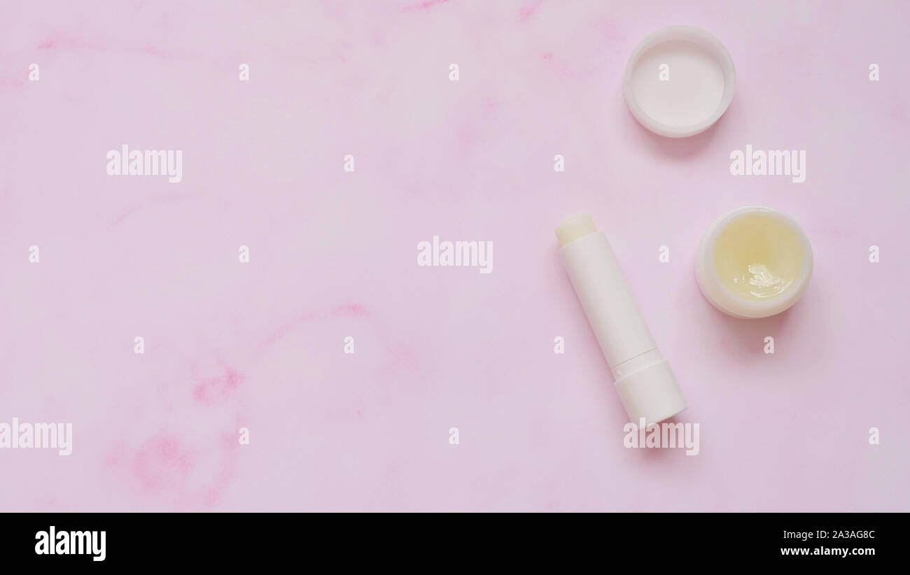 Top view of a tube of white lip balm and a small round container of solid perfume Stock Photo