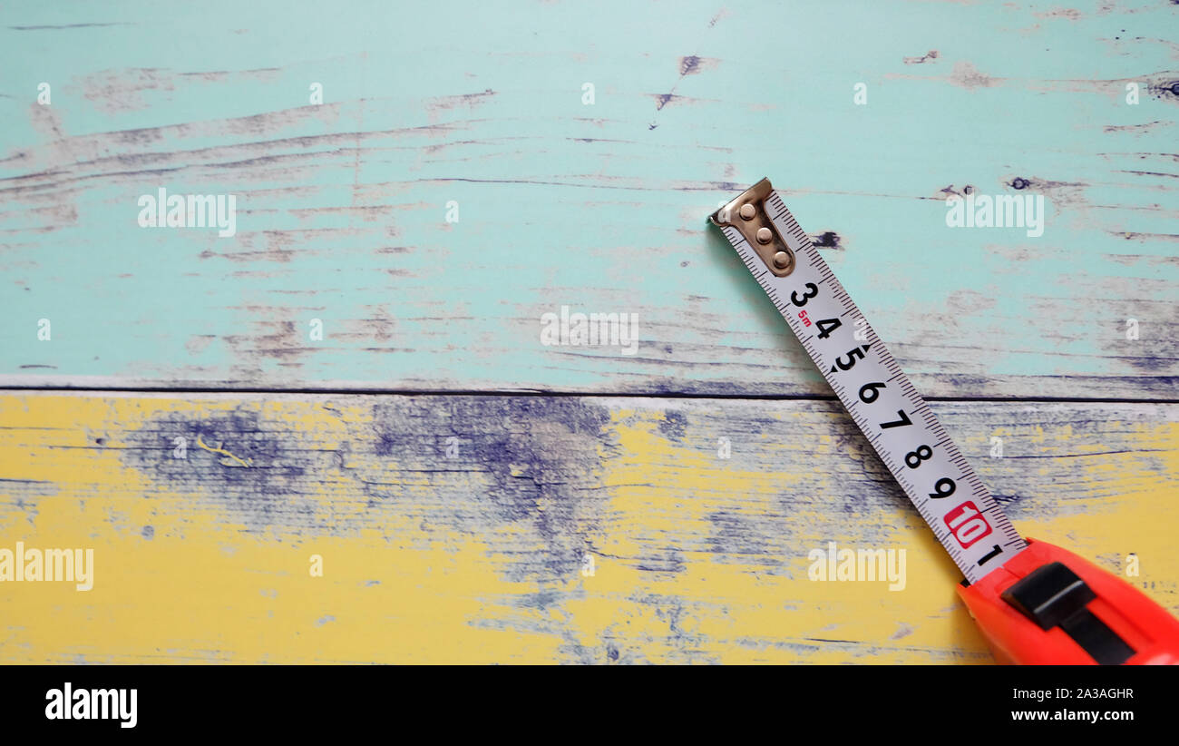 A measuring tape with centimeter unit, on a vibrant wooden background. Stock Photo