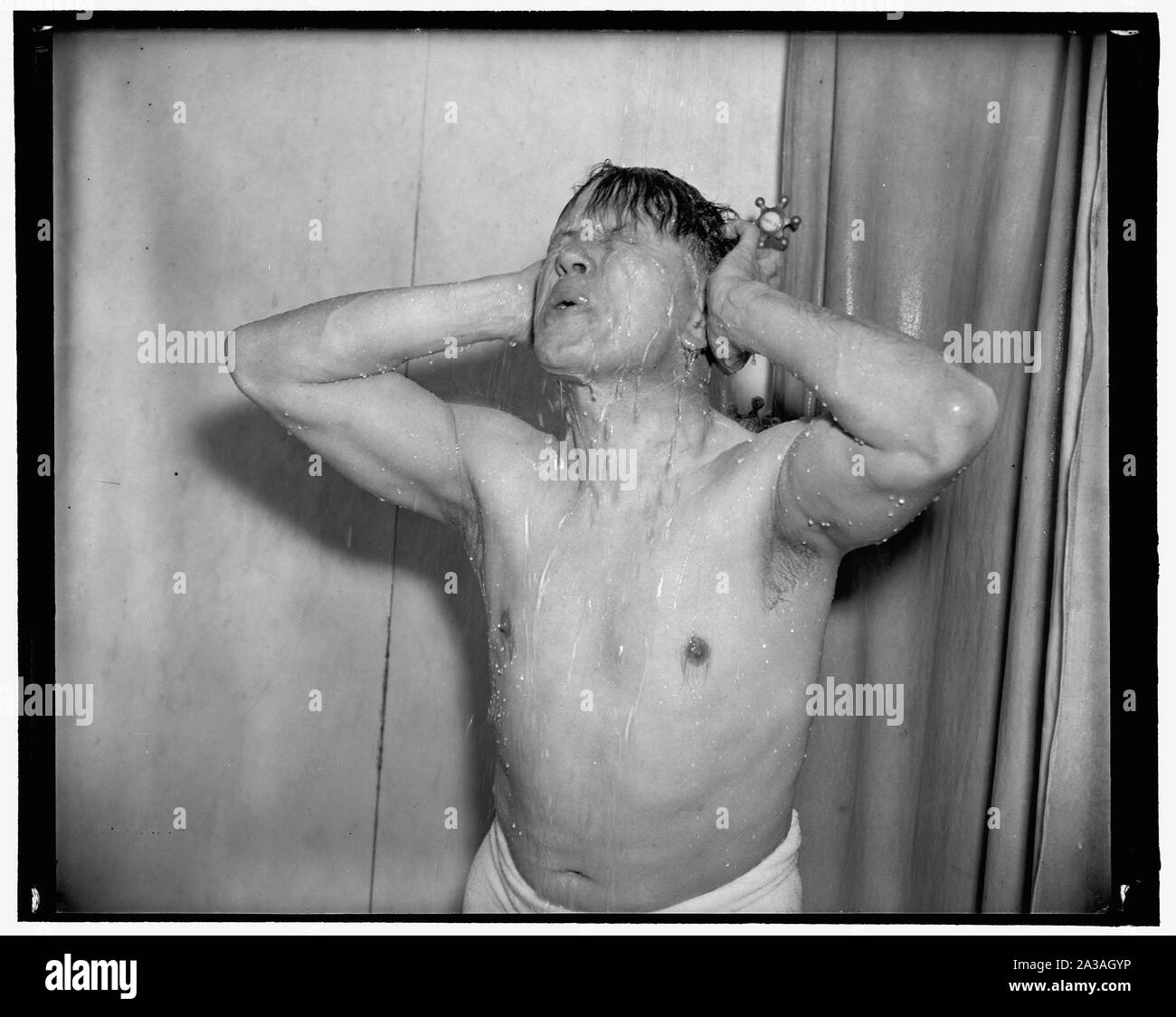 Senator Ellender. Following a round with the rowing machine and medicine ball, he finishes off with a hot shower, gradually tapering off to icy cold. 'Makes me ready to tackle the world,' 3-17-39 Stock Photo
