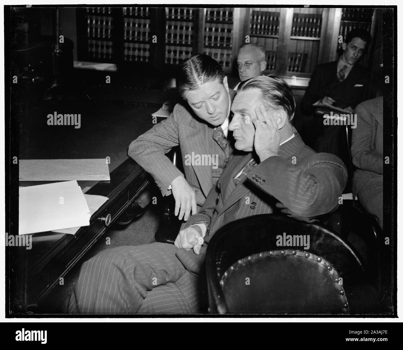 Senators LaFollette and NYE confer on Ludlow bill. Washington, D.C., May 10. Senator Robert M. LaFollette, Jr., who was first witness before the Senate Judiciary Subcommittee hearing witnesses on the Ludlow Resolution to have war declarations submitted to vote by the people, finished his testimony and leaned over the shoulder of Senator Gerald -Mun'tions- NYE to tell him of a new argument for the resolution Stock Photo