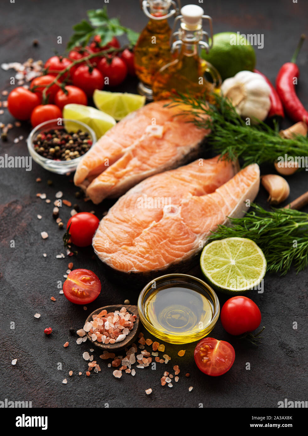 Raw salmon steaks and ingredients on a black slate board Stock Photo ...
