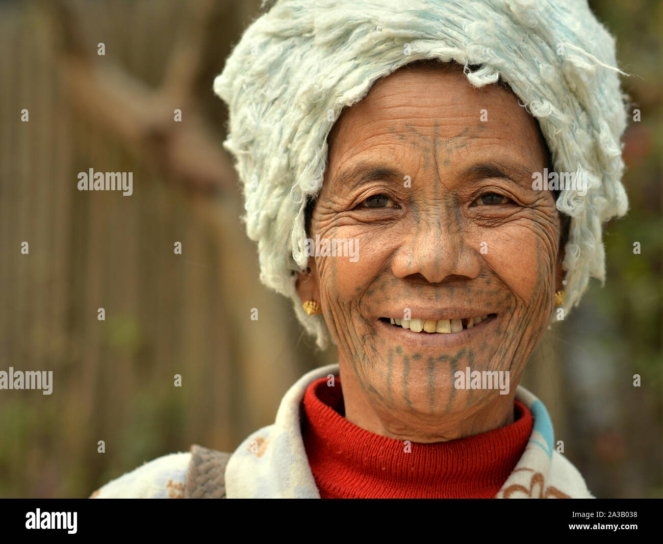 Elderly Chin Muun tribal woman ("spider woman") with traditional facial tattoo smiles for the camera. Stock Photo