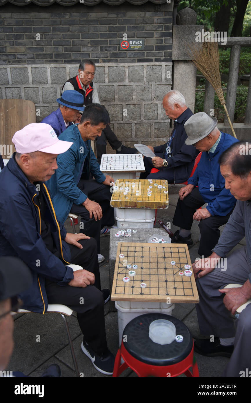 Men playing board games outside in the park in Seoul, South Korea Stock