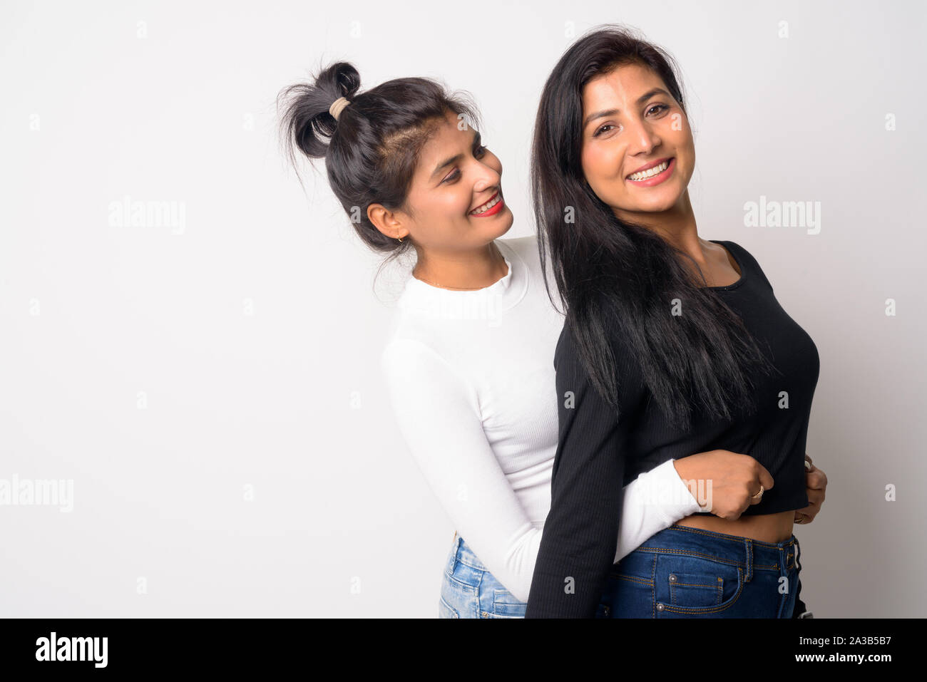 Two happy young beautiful Persian women embracing together Stock Photo