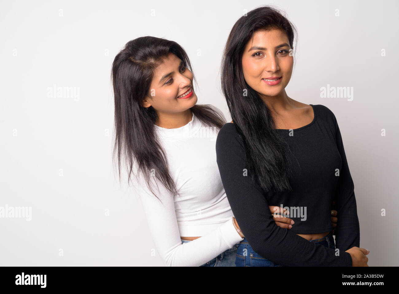 Two happy young beautiful Persian women embracing together Stock Photo