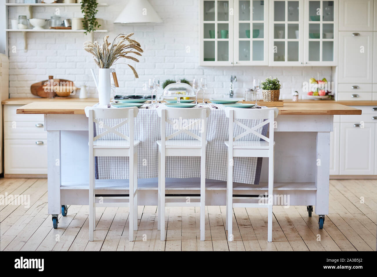 Beautiful White Wooden Kitchen With Island Table And Chairs Stock Photo Alamy