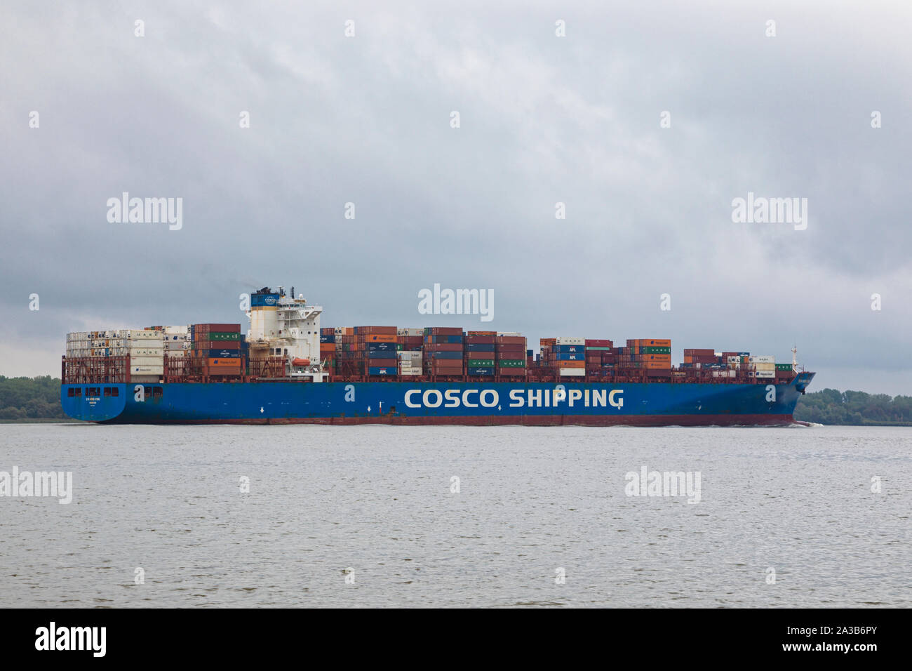 Container ship XIN HONG KONG, owned by China COSCO Shipping Corporation, on Elbe river heading to Hamburg Stock Photo