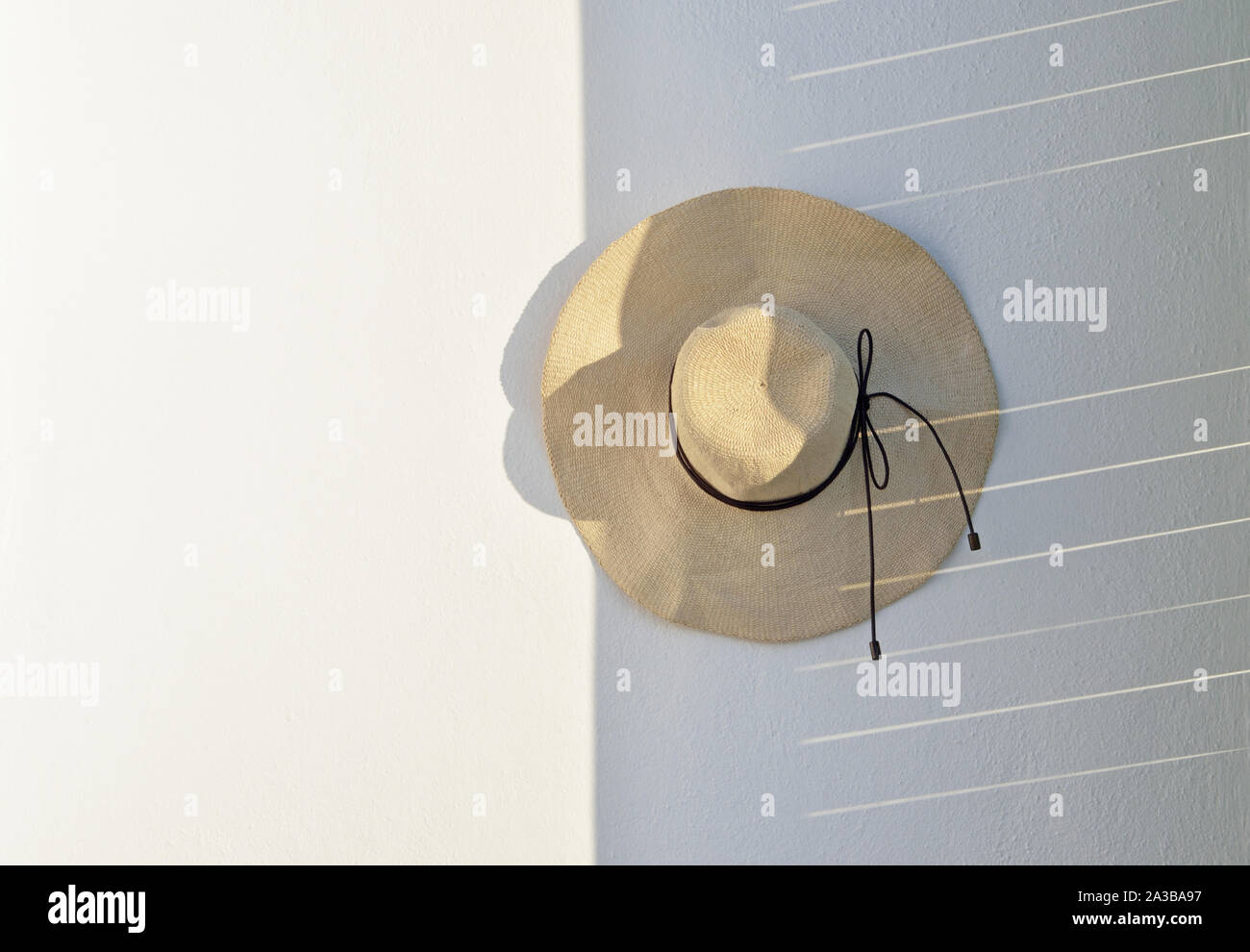 Straw hat hanging on wall Stock Photo