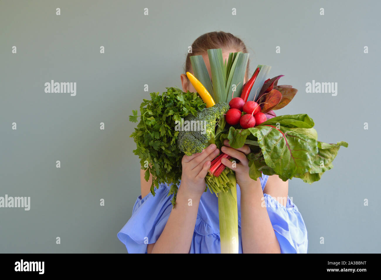 Girl holding vegetables bouquet in front of face Stock Photo