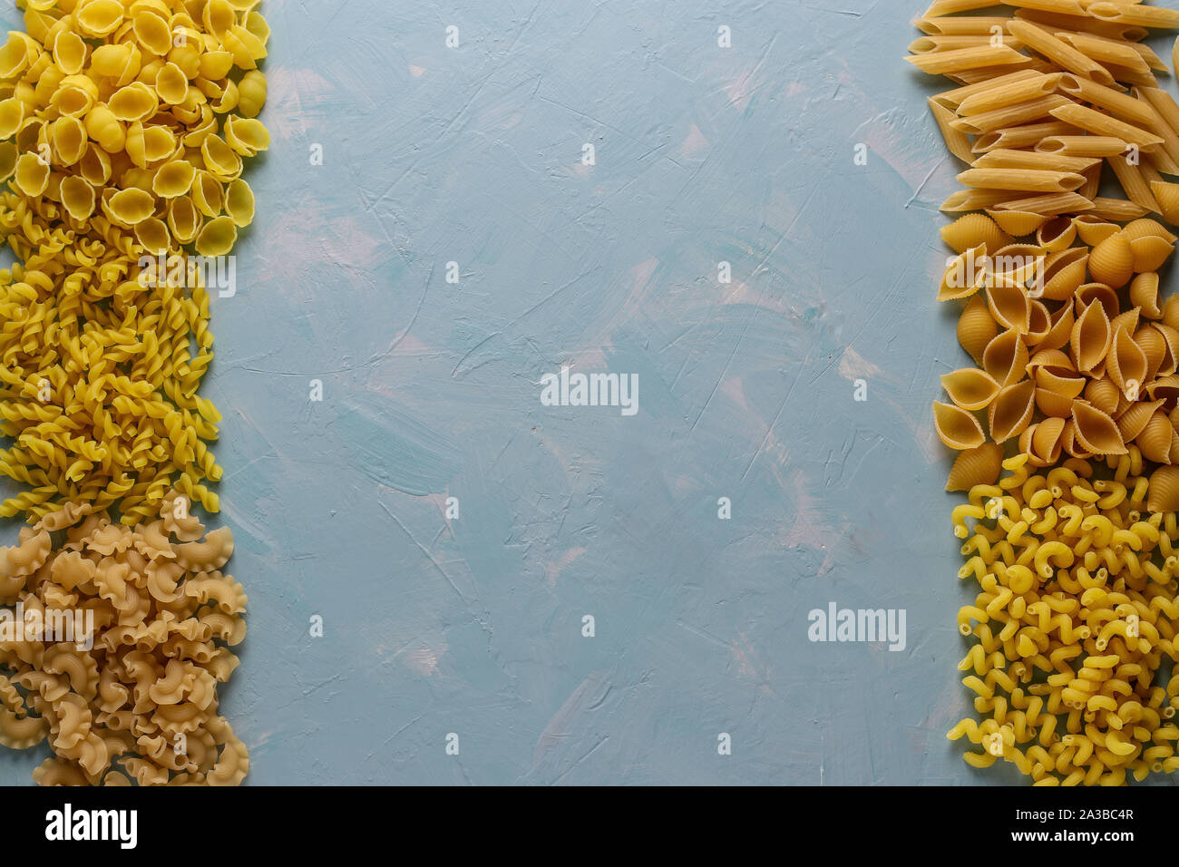 Assorted Italian pasta: Penne rigate, Rotelle, Conchiglie, Cavatappu, Fusilli, Cellentani, horizontal orientation, copy space Stock Photo