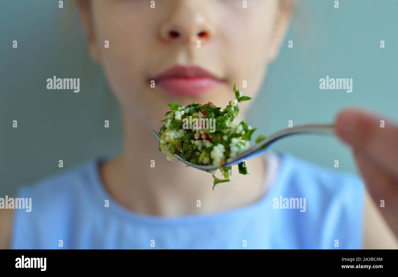 Crop close up shot of girl eating salad with a fork Stock Photo