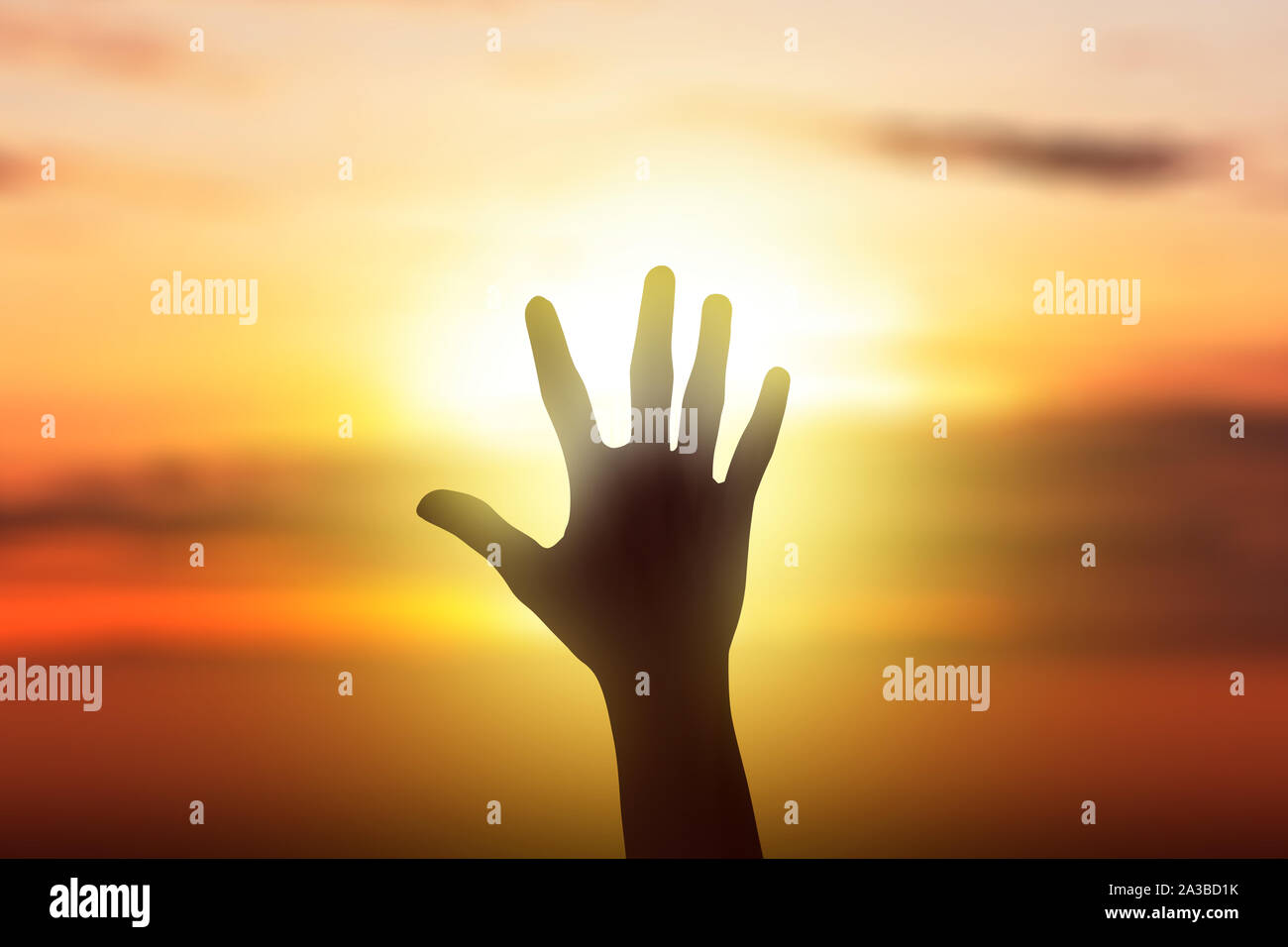 Human hands with an open palm facing sunset sky background Stock Photo