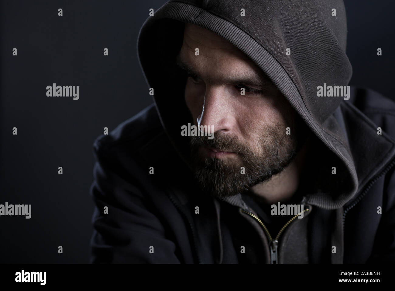 Thoughtful man with hood looking sad. Stock Photo