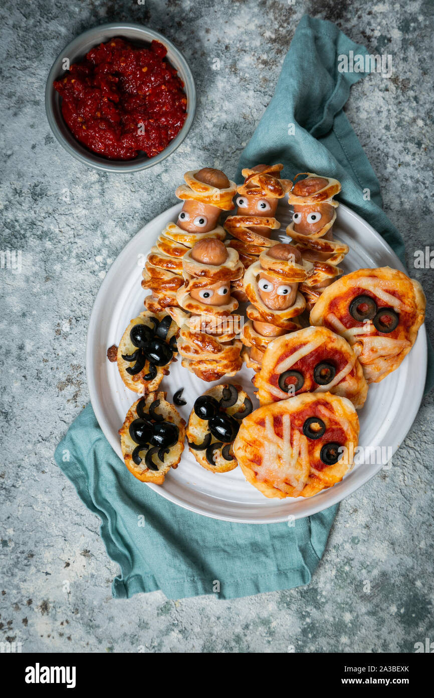 Halloween kids party food - pizza, sausage mummies, spiders Stock Photo