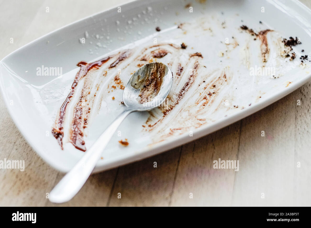 An empty plate after a chocolate dessert has been eaten in a restaurant. Stock Photo